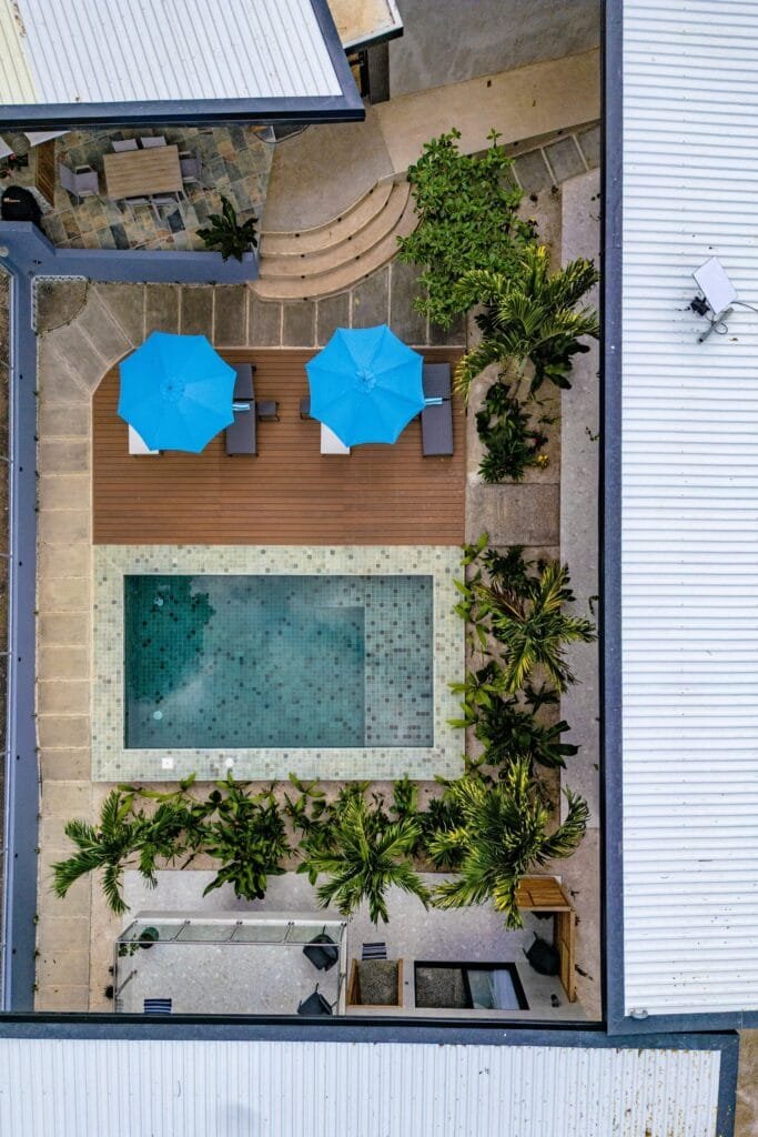 Vista aérea de la piscina de Nori Villas con palmeras y sombrillas