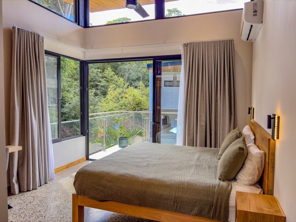Habitación del apartamento Colibrí con ventanales de doble altura y vista al balcón