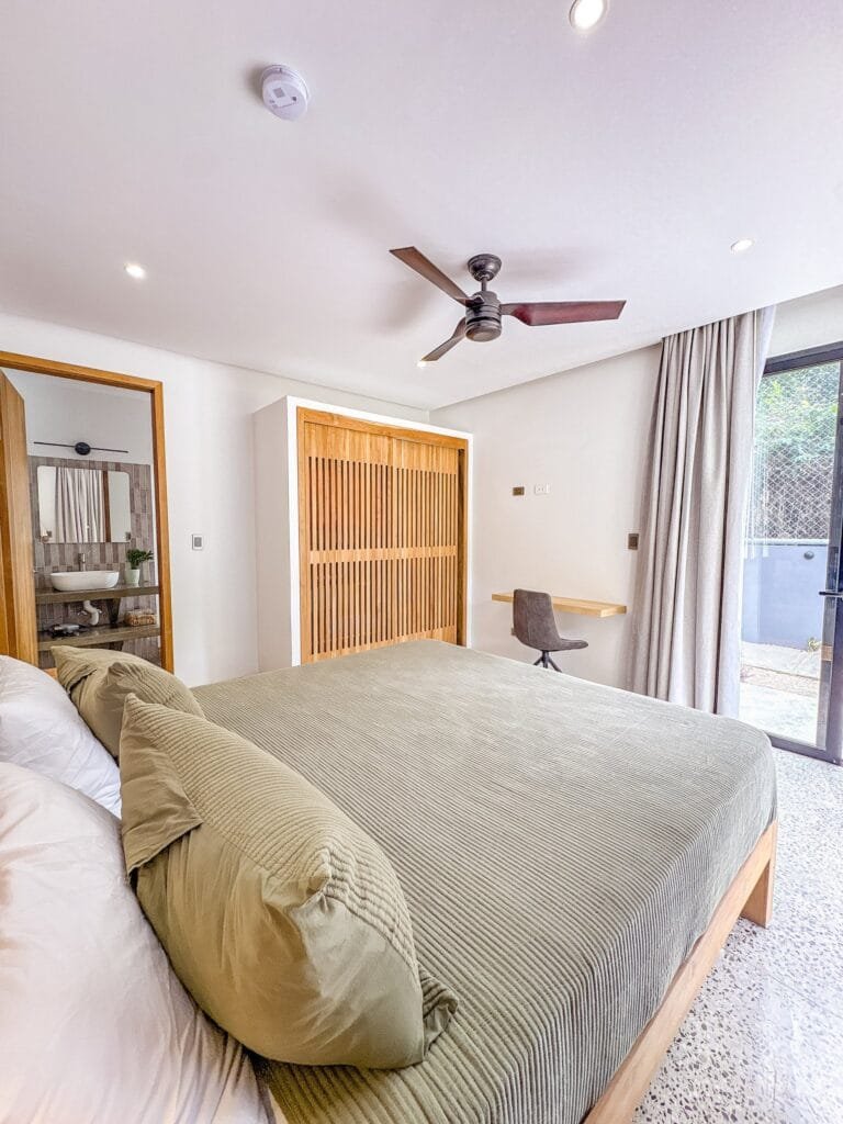 Habitación del apartamento Perico con clóset de celosía de madera y ventilador de techo