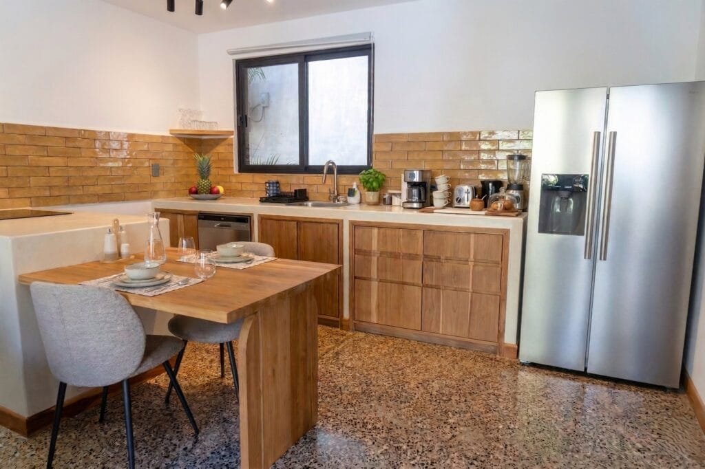 Cocina del apartamento Perico con pared de ladrillo amarillo y rincón de comedor