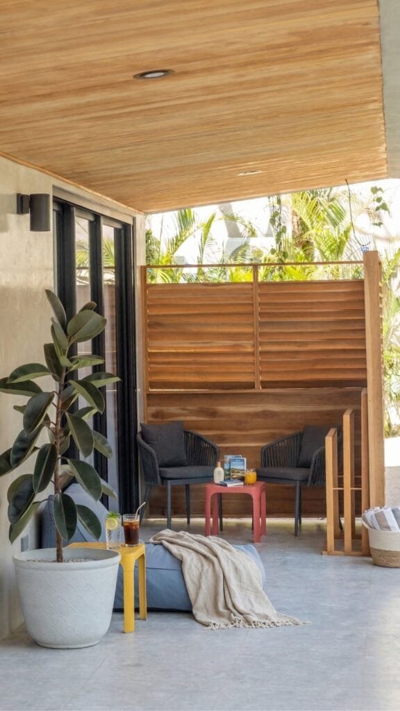 Terraza techada del apartamento Quetzal con celosías de madera y sillones