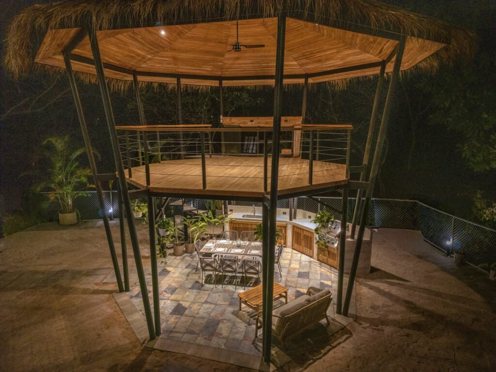 Rancho de techo de paja de dos pisos de la villa Nori, iluminado de noche