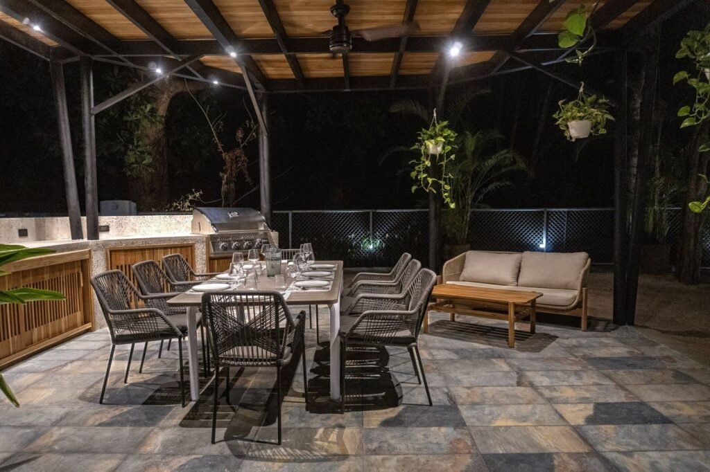 Rancho con BBQ y mesa larga de comedor, de noche